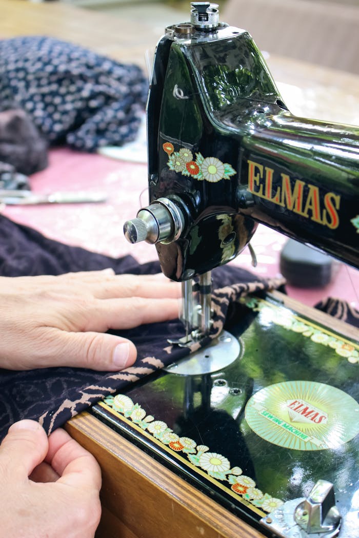 Close-up of a vintage sewing machine being used for fabric stitching.